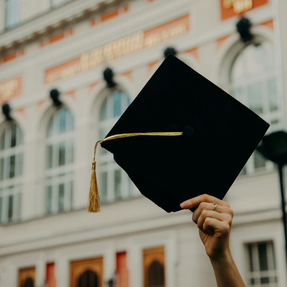 Graduation cap being held in the air